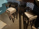 trois tabourets placés devant un bar dont le mur est bleu