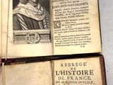 un livre ouvert sur lequel est posée la photo d'un homme coiffé d'un chapeau