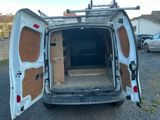 une camionnette blanche dont les portes sont ouvertes, garée sur un parking