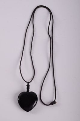 necklace with a black heart on a black cord on a white background
