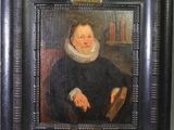 portrait d'un homme vêtu d'une robe noire, assis sur une chaise, un livre à la main