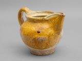 une image représentant un vase jaune sur fond gris
