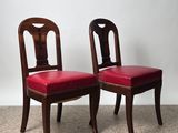 pair of mahogany chairs with red upholstered leather seats