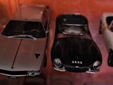 trois voitures exposées dans une vitrine