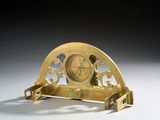 une horloge posée sur un support sur une table