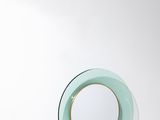 un petit miroir rond accroché au mur au-dessus d'un lavabo