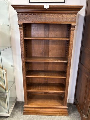 une vieille bibliothèque en bois avec une vitrine dans un coin