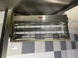 a large metal heater hanging from the ceiling in a kitchen