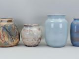 four vases sitting next to each other on a table