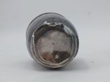 a close up of a silver vase on a white surface