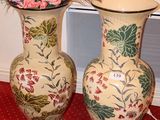 deux vases remplis de fleurs posés sur un tapis rouge