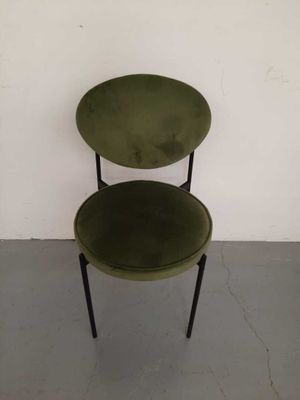 a green chair sitting in front of a white wall