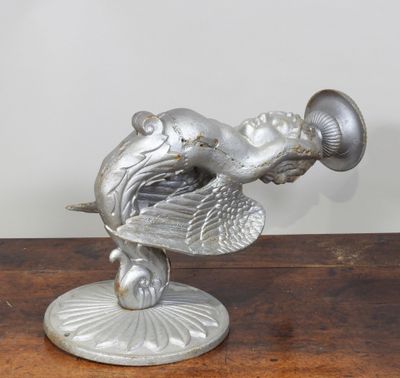 une statue en argent représentant un oiseau, posée sur un socle