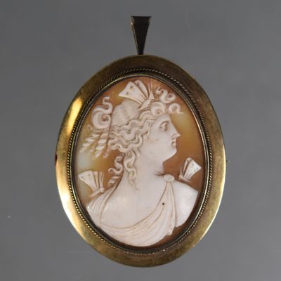 un camée ancien représentant une femme avec une fleur dans les cheveux