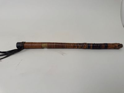 a close up of a wooden stick with a tassel on top of it