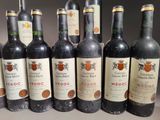 several bottles of wine are lined up in a row on a table