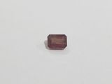 a square shaped red ruby stone on a white surface