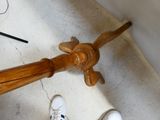 a person standing next to a wooden umbrella on the floor