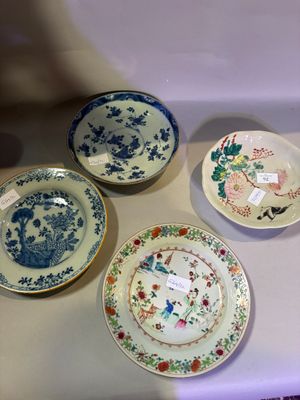 four plates on display on a table with tags on them