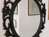 un miroir sur le mur au-dessus d'un lavabo dans une salle de bains
