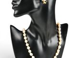 une tête de mannequin noire ornée de perles et de boucles d'oreilles en or