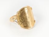 Gros plan sur une bague en or ornée d'une pièce de monnaie