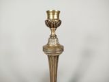 brass candle holder with a glass candle on top of it