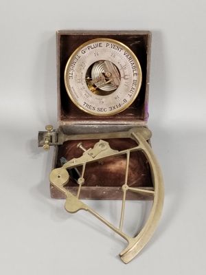 une boussole ancienne plaquée laiton, accompagnée d'un coffret en bois et d'une poignée en métal