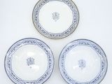 three blue and white plates with designs on them on a white surface