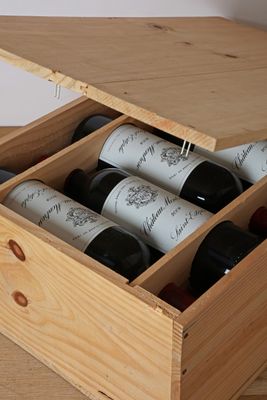 bottles of wine are in a wooden box on a table