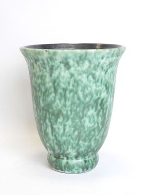 a green vase that is sitting on a white surface