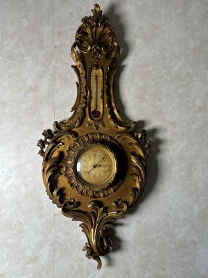 une horloge dorée accrochée au mur d'une pièce