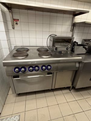 a kitchen with a stove, oven, and sink in it