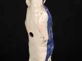 a white and blue vase with a bird on it ' s head