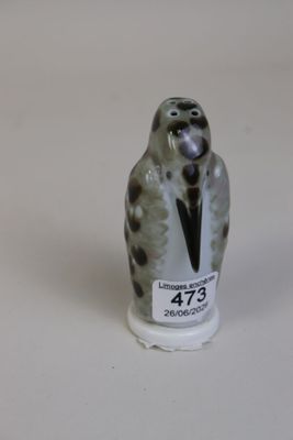 une petite figurine représentant un oiseau sur un fond blanc