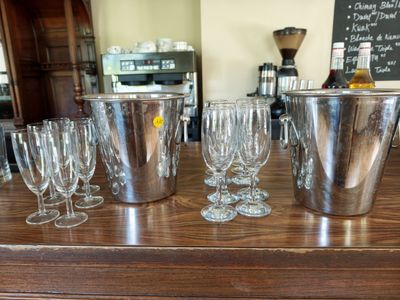 bottles and glasses on a bar with a menu in the background