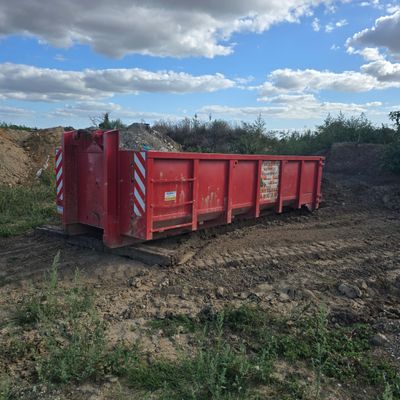 a red dump truck that is parked in the dirt