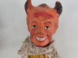 a small doll with a devil face on it ' s head