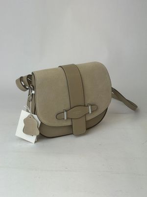 beige leather cross body bag with metal buckles and a tag