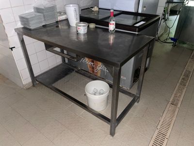 une photo d'une cuisine avec une table et une cuisinière
