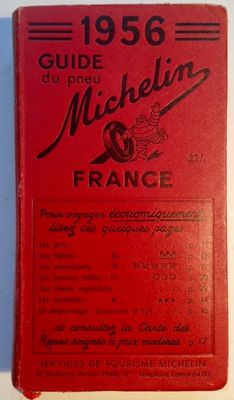 un livre rouge posé sur une table à côté d'un mur blanc