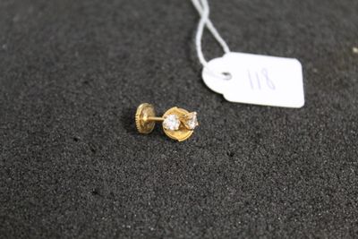 a pair of gold and diamond earrings on a black surface