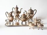 a silver tray with a silver tea set on top of it