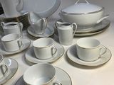 a lot of white dishes and cups on the table