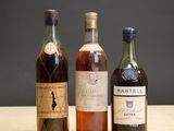 trois bouteilles de vin sont alignées sur une table en bois