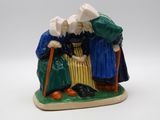 une figurine représentant deux personnes debout l'une à côté de l'autre