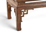 a small wooden table with a carved top on a white background