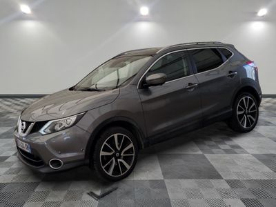 un SUV Nissan gris garé sur un sol en damier dans un garage