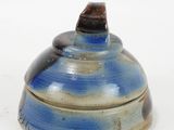 a blue and white bowl with a lid on a white surface