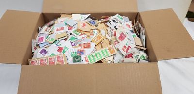 a cardboard box filled with postage stamps sitting on a bed